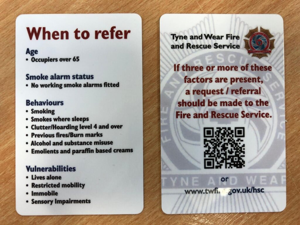 Picture of Tyne and Wear Fire and Rescue Service Safe and Well Referral Cards. Front and back images. Highlights key risk factors for fire - Age • Occupiers over 65 Smoke Alarm Status • No working smoke alarms fitted Behaviours • Smoking • Smokes where sleeps • Clutter/hoarding level 4 and over • Previous fires/burn marks • Alcohol and substance misuse • Emollients and paraffin-based creams Vulnerabilities • Lives alone • Restricted mobility • Immobile • Sensory impairments On the back, it advises that if three or more of the risk factors are present, a request/referral should be made to the Fire and Rescue Service via www.twfire.gov.uk/hsc